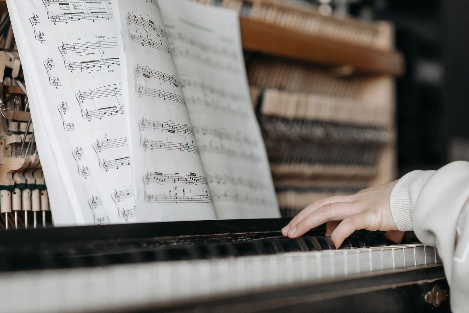 Musician playing piano with open sheet music during focused practice