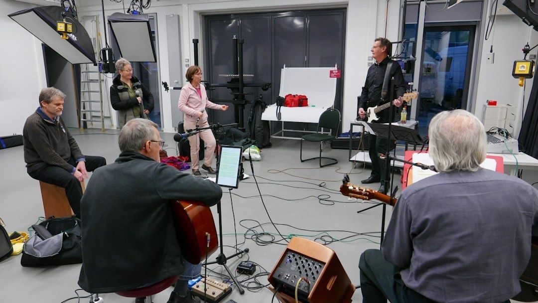 Musicians rehearsing together with guitars, microphones, and audio equipment